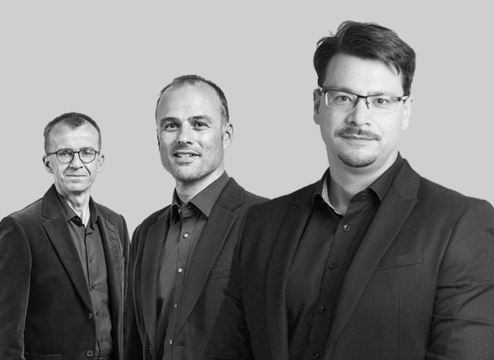 Drei Herren lächeln in die Kamera
